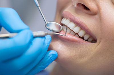 A dental hygienist performing a cleaning procedure on a patient s teeth using professional tools and equipment.