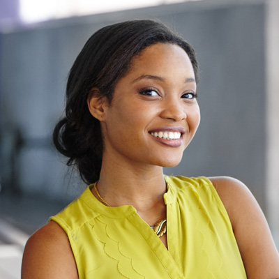 A woman with a bright smile poses confidently against a backdrop.