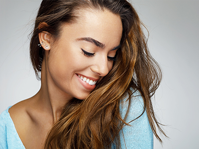 This image features a woman with long hair smiling at the camera from two different angles, against a light background.