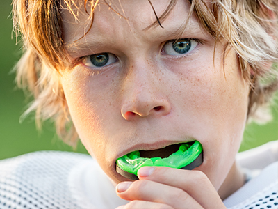 The image features two photos side by side  on the left, a young boy with blonde hair is holding a green object close to his mouth  on the right, the same boy appears older with a similar object in his mouth, now showing teeth damage.